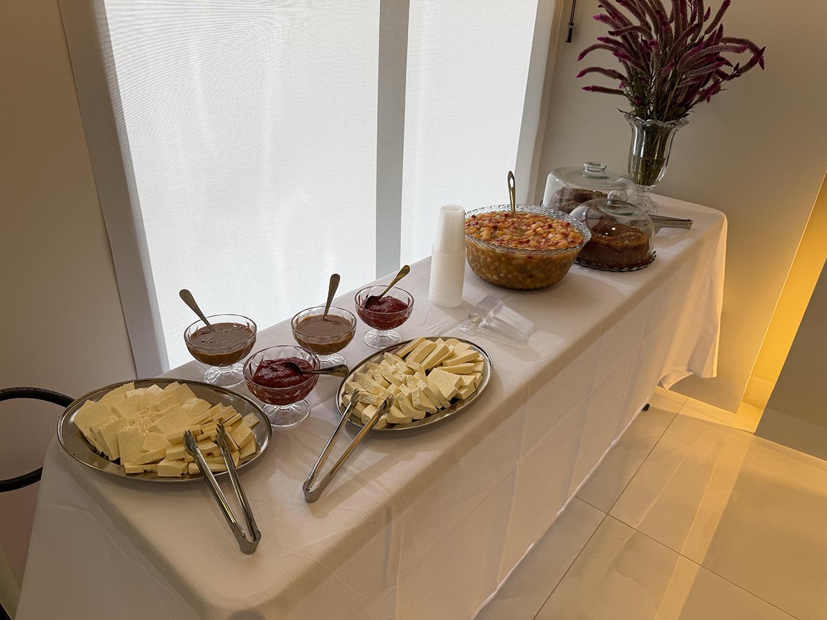 Mesa de buffet com queijos, molhos, salada e bolos